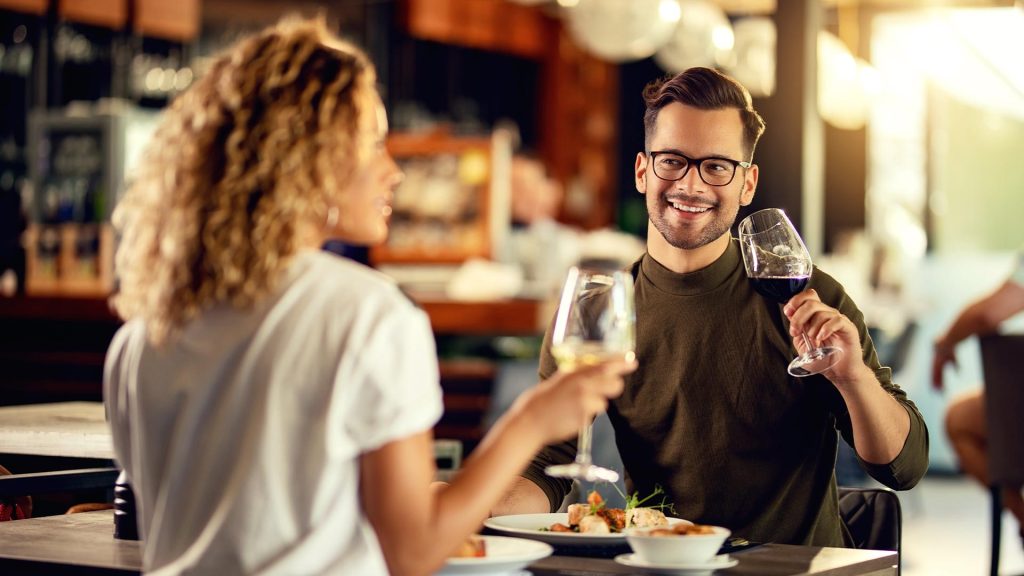 Man and woman on date in restaurant with wine